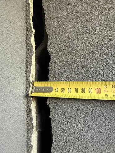 Tape measure held across the crack at the garage
